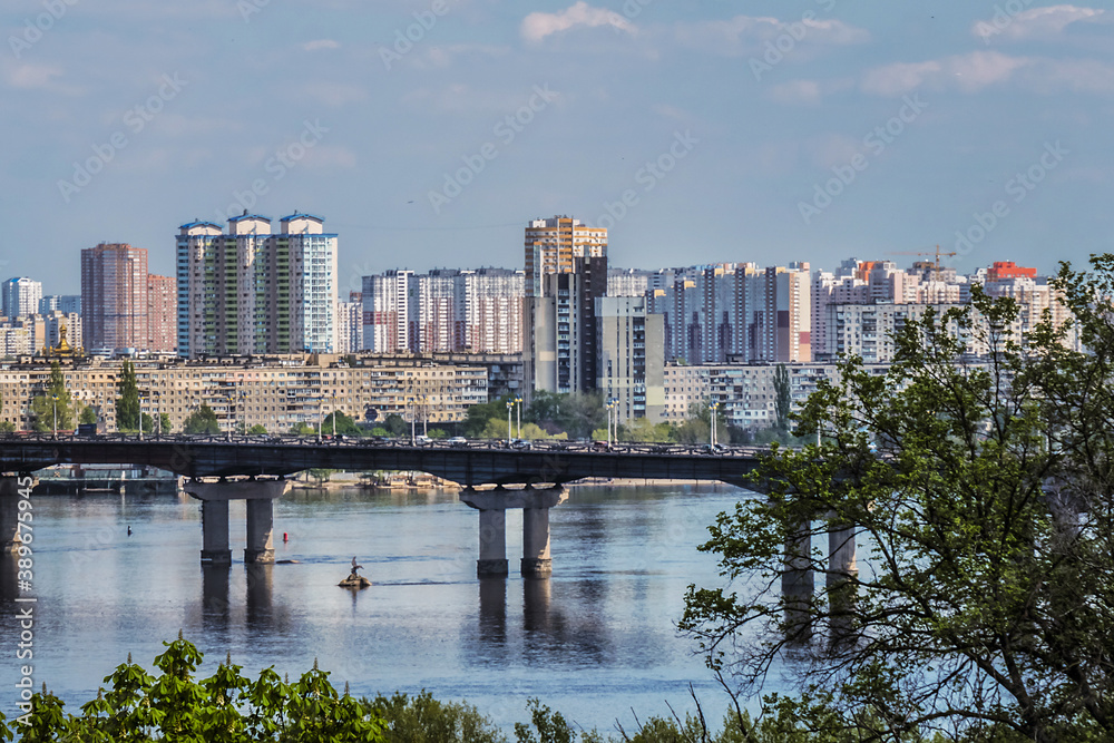 Fototapeta premium View of Dnieper River with Paton Bridge and architecture of Left Bank of Dnieper in Kyiv. Kyiv, Ukraine.