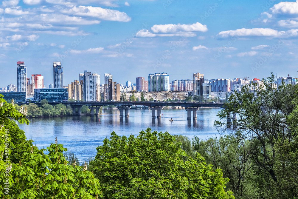 View of Dnieper River with Paton Bridge and architecture of Left Bank of Dnieper in Kyiv. Kyiv, Ukraine.