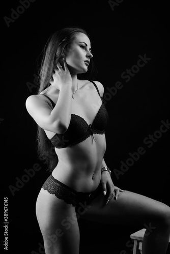 Sexy fashion brunette woman with long dark hair in blue lingerie, isolated on dark gray background