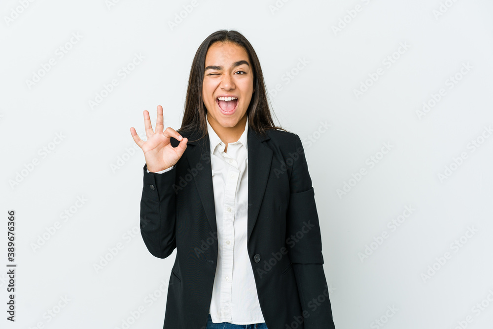 Young asian bussines woman isolated on white background winks an eye and holds an okay gesture with hand. Young asian bussines woman isolated on white background winks an eye and holds an okay gesture with hand.