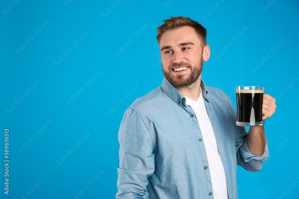 Handsome man with cold kvass on blue background. Traditional Russian summer drink Handsome man with cold kvass on blue background. Traditional Russian summer drink