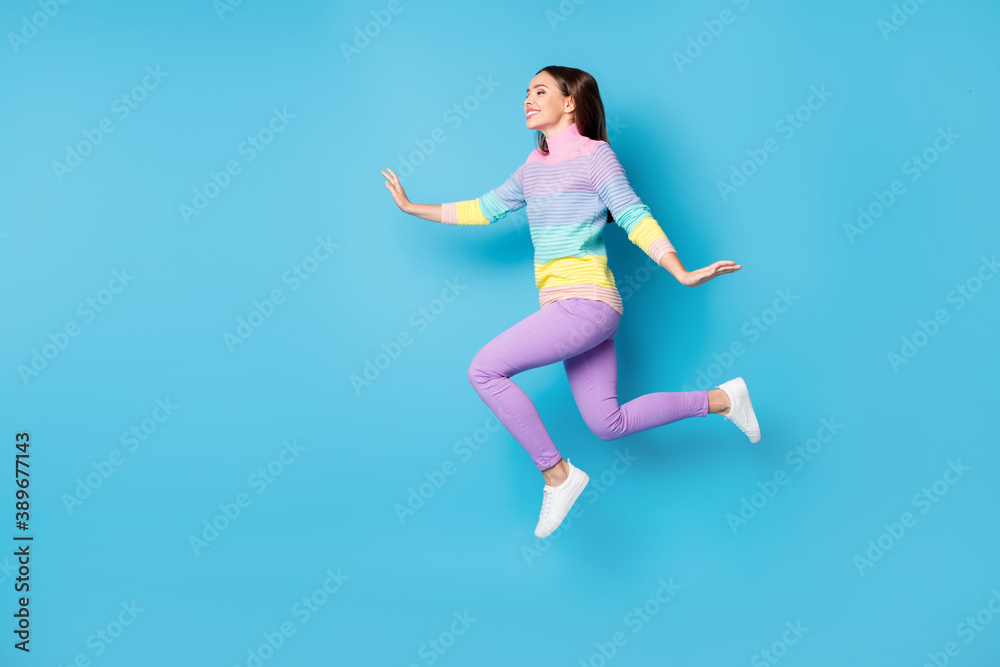 Full length body size view of pretty dreamy cheery thin girl jumping walking having fun isolated over bright blue color background Full length body size view of pretty dreamy cheery thin girl jumping walking having fun isolated over bright blue color background