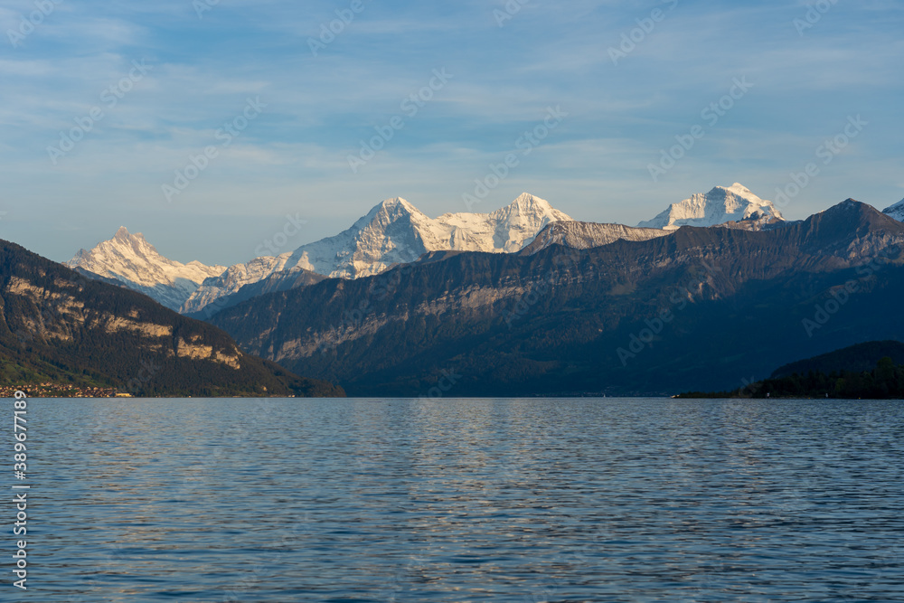view of the lake with swiss alps mountains in background in autumn
