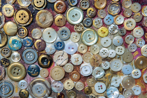 Different color buttons for clothes on a painted surface. Close-up