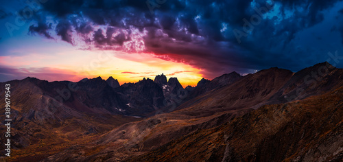 Beautiful Aerial Panoramic View of Dramatic Mountains and Scenic Alpine Lake during Fall in Canadian Nature. Dramatic Colorful Sunset Artistic Render. Tombstone Territorial Park, Yukon, Canada.