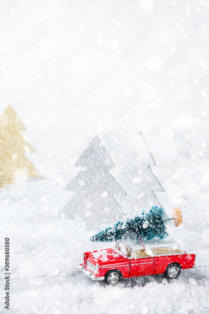 Toy car carrying christmas tree in a snow forest Toy car carrying christmas tree in a snow forest
