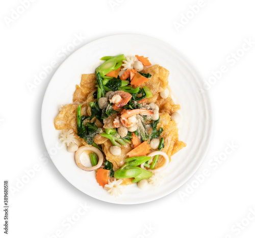 Fried noodle with seafood and vegetable in round white dish isolated on white background. Thai Food concept