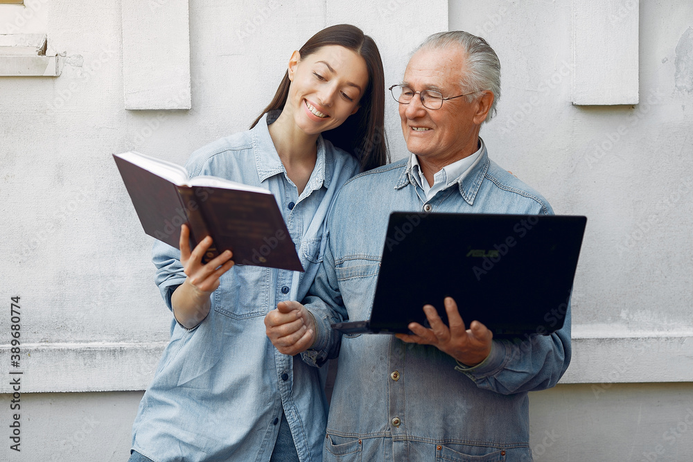 Grandfather with granddaughter. Girl teaching her grandfather. Using laptop. Grandfather with granddaughter. Girl teaching her grandfather. Using laptop.