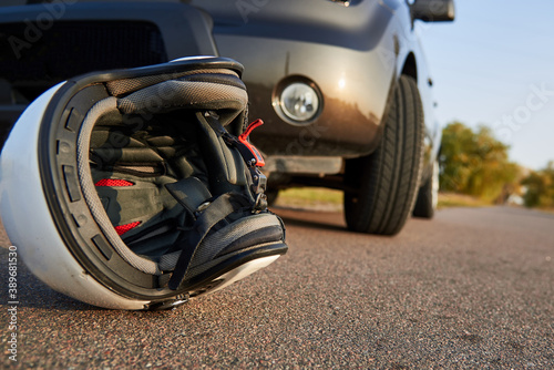 Photo of car, helmet and motorcycle on the road, the concept of road accidents.