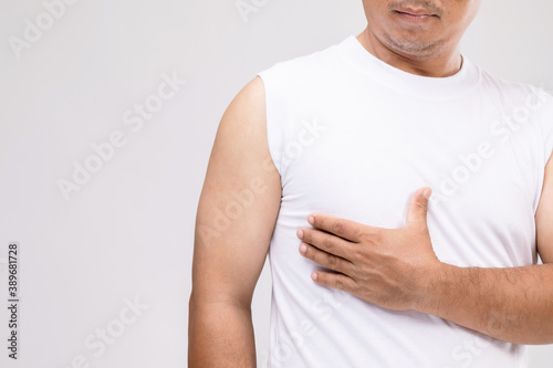 Breast cancer in men concept : Portrait Asian man in posture of care or protect himself from breast cancer. Studio shot isolated on grey