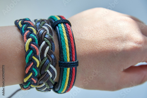 Three bracelets made of fabric and leather ropes on a woman's hand.