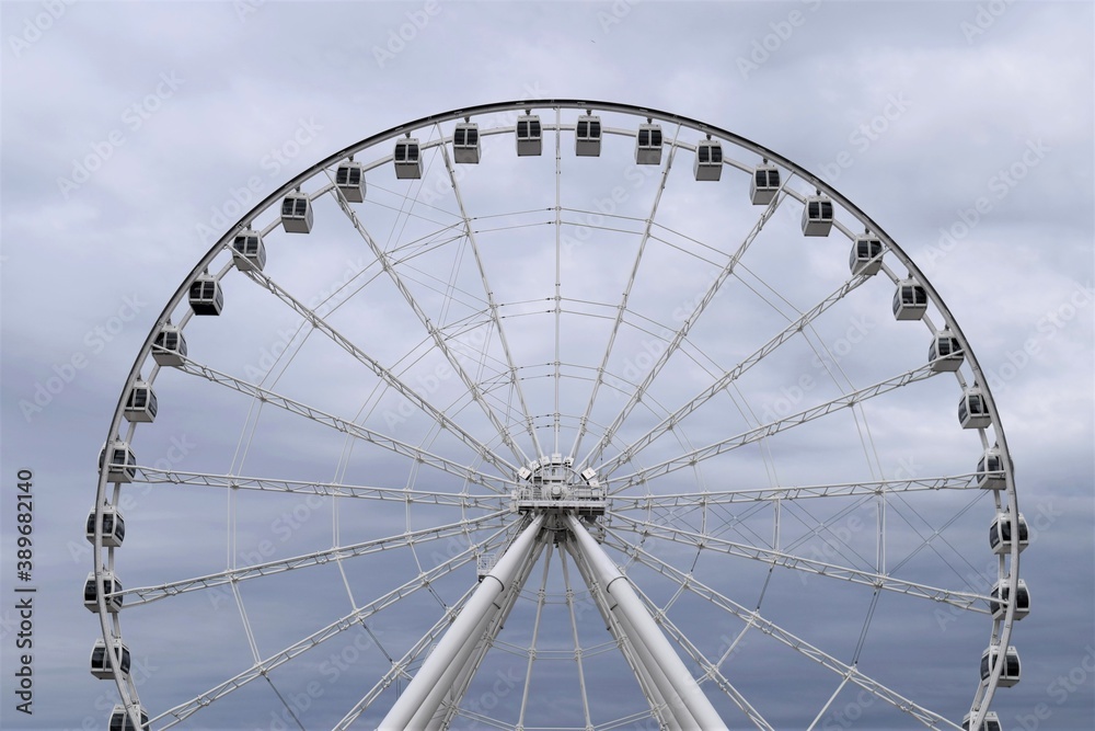 A Huge Ferris Wheels under a Cloudy Sky at a Amusement Park