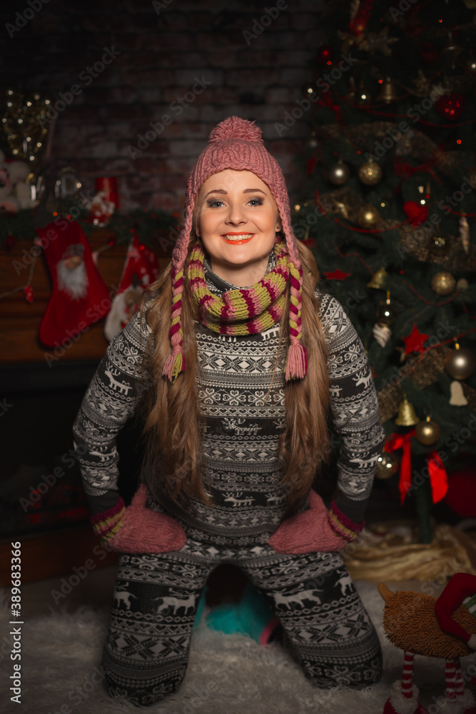 Young woman in knitted hat with mittens smiling