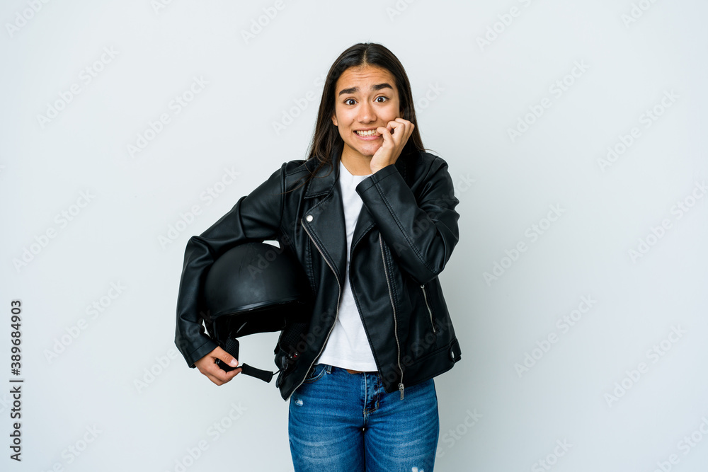 Young asian woman holding a motorbike helmet over isolated background biting fingernails, nervous and very anxious. Young asian woman holding a motorbike helmet over isolated background biting fingernails, nervous and very anxious.