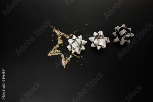 Christmas silver decorations on black background. Flat lay design.