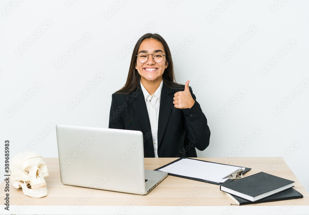 Young traumatologist asian woman isolated on white background smiling and raising thumb up