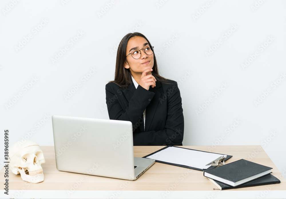 Young traumatologist asian woman isolated on white background looking sideways with doubtful and skeptical expression. Young traumatologist asian woman isolated on white background looking sideways with doubtful and skeptical expression.