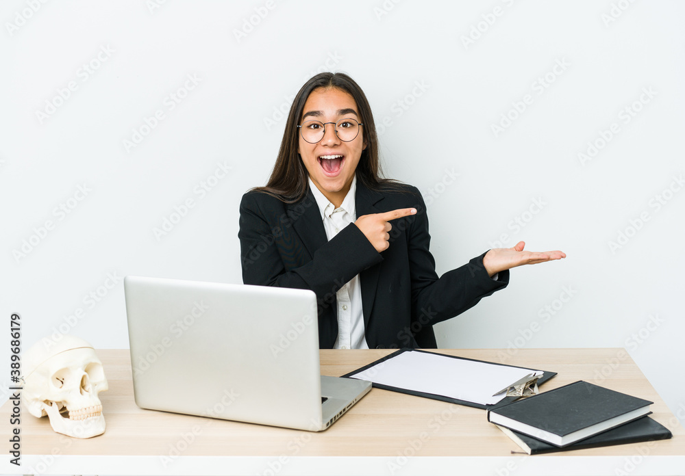 Young traumatologist asian woman isolated on white background excited holding a copy space on palm. Young traumatologist asian woman isolated on white background excited holding a copy space on palm.