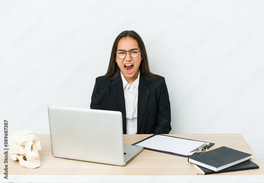 Young traumatologist asian woman isolated on white background screaming very angry and aggressive. Young traumatologist asian woman isolated on white background screaming very angry and aggressive.