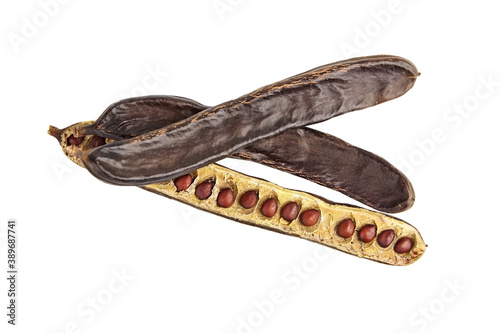 Dried carob tree fruits with seeds isolated on white background.