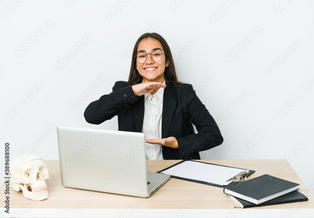Young traumatologist asian woman isolated on white background holding something with both hands, product presentation. Young traumatologist asian woman isolated on white background holding something with both hands, product presentation.