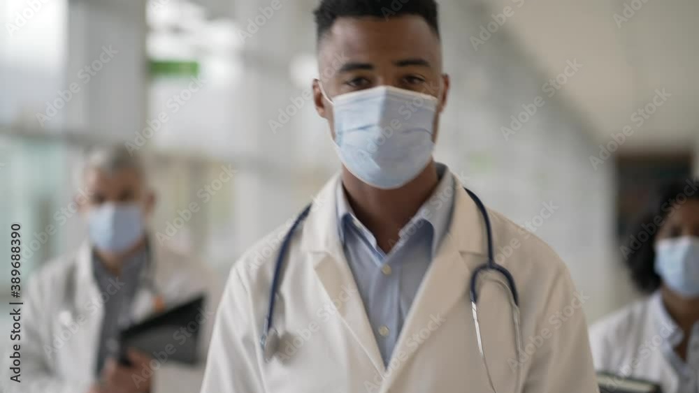 Group of doctors standing in hospital corridor with face mask Group of doctors standing in hospital corridor with face mask