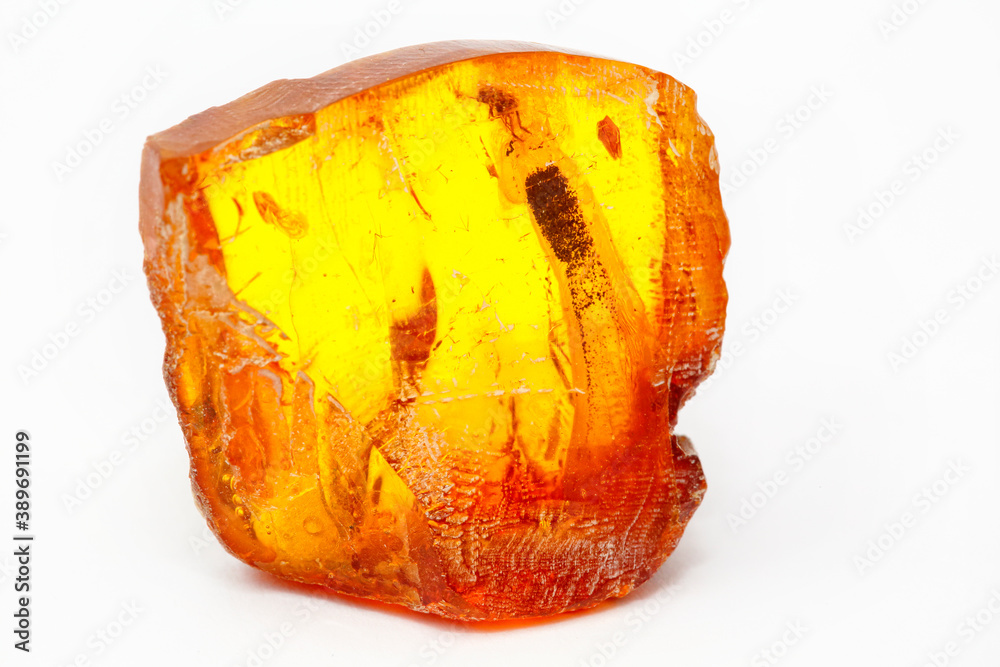 A piece of transparent yellow amber with inclusions on a white background. Natural fossil fossilized resin. Crystal. Colored mineral copal. Sun stone. Material for jewelry. Ancient tar A piece of transparent yellow amber with inclusions on a white background. Natural fossil fossilized resin. Crystal. Colored mineral copal. Sun stone. Material for jewelry. Ancient tar