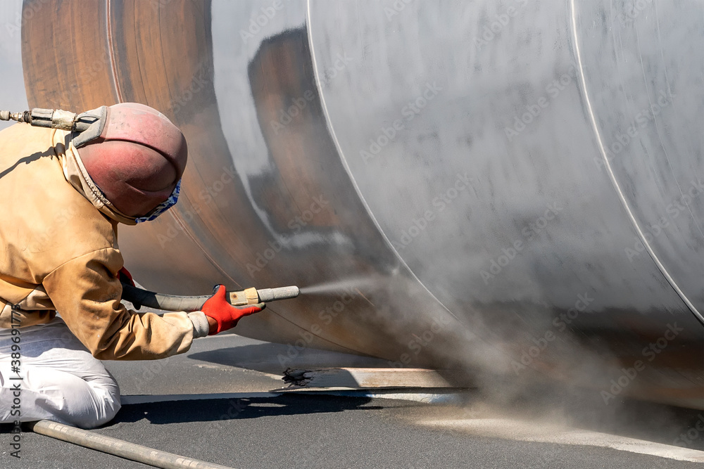 View of the sandblasting or abrasive blasting. Abrasive blasting, more commonly known as sandblasting, is the operation of forcibly propelling a stream of abrasive material against a surface.