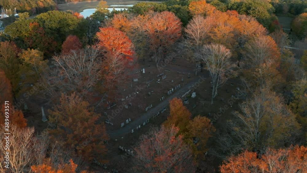 Aerial shot of a cemetery surrounded by colorful autumn trees, sunset Aerial shot of a cemetery surrounded by colorful autumn trees, sunset