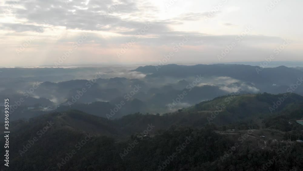 Aerial view of mountain landscape at sunrise with fog and majestic sun rays, pan up Aerial view of mountain landscape at sunrise with fog and majestic sun rays, pan up