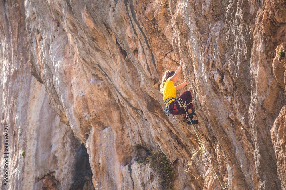 A strong woman climbs a beautiful orange rock. A strong woman climbs a beautiful orange rock.