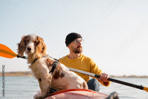 Bild auf Leinwand Man with a dog in a canoe on the lake