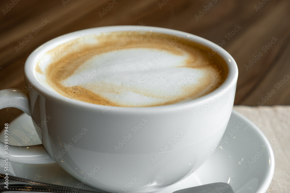 Obraz premium closed-up of hot drink coffee in white mug on brown wood table