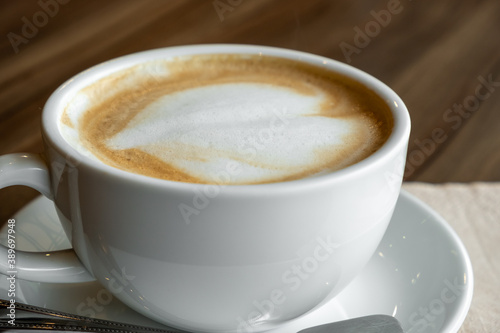 closed-up of hot drink coffee in white mug on brown wood table