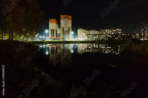 the new residential complex stands on the picturesque shore, sparkling with lights and reflected in the mirror-like surface of the lake