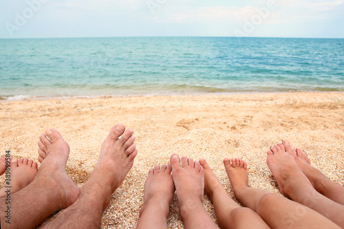 A Legs of the beautiful whole family on the sand near the sea background