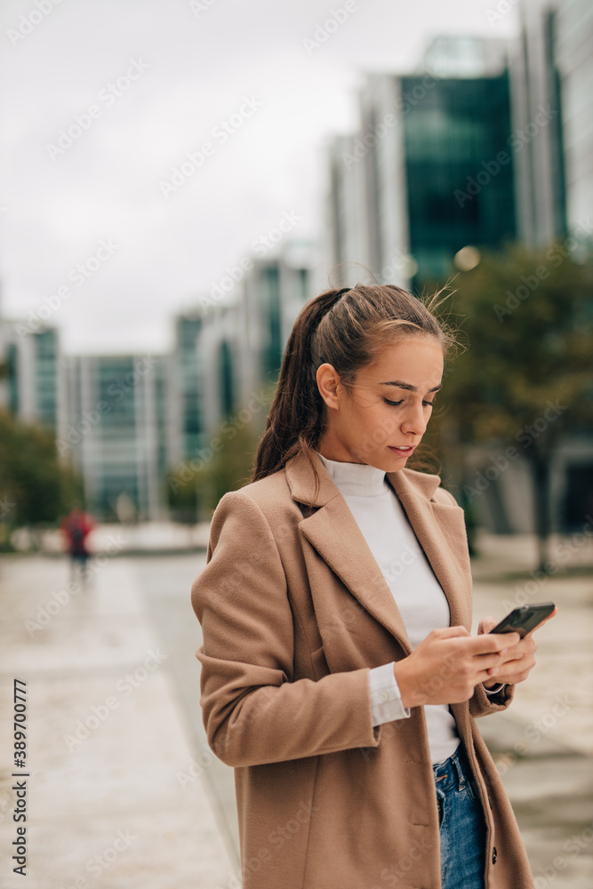 Girl walking and holding her smart phone.