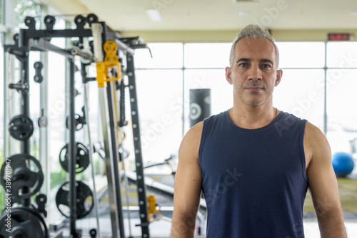 Portrait of mature handsome Persian man at the gym