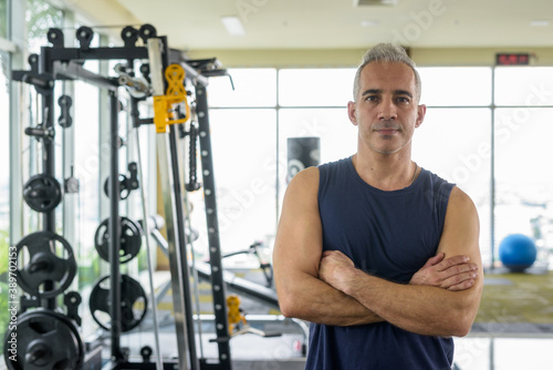 Mature handsome Persian man with arms crossed at the gym © Ranta Images