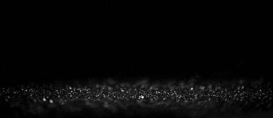 Black friday bokeh background. Elegant dark blur layout design. Silver and black glitter place on table with spotlight. Luxury abstract banner with copyspace.