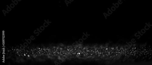 Black friday bokeh background. Elegant dark blur layout design. Silver and black glitter place on table with spotlight. Luxury abstract banner with copyspace.