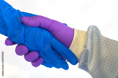 handshake in a blue and purple gloves isolated on white background