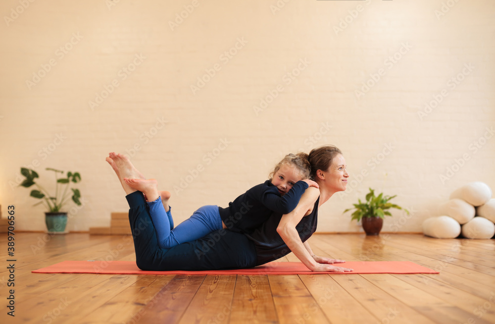 Mother and daughter doing pilates in a yoga studio