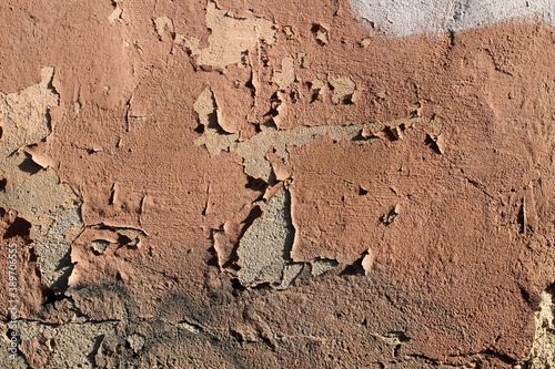 texture of an old wall with cracked paint and peeling plaster