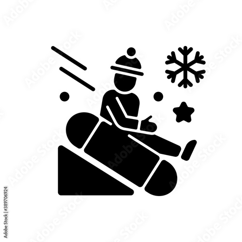 Snow tubing black glyph icon. Fun children ride downhill. Extreme sledging. Winter activity. Festive season recreation for kids. Silhouette symbol on white space. Vector isolated illustration