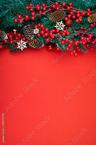 Christmas decorations on the red background. Top view with copy space for your text. Vertical photo.