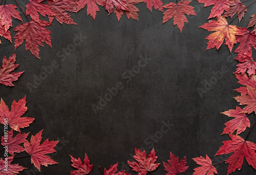 Autumn leaves over black stone background with copy space