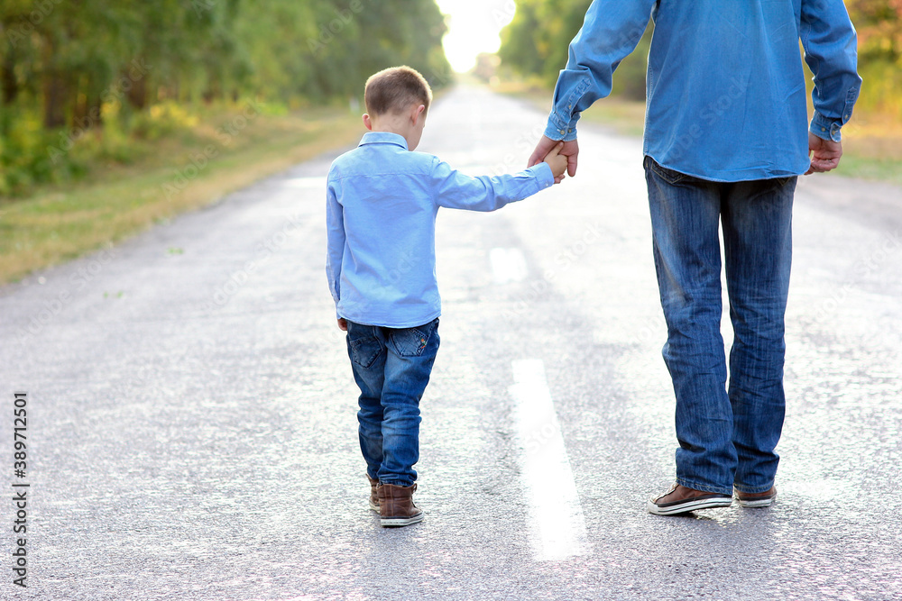 Obraz premium A Happy parent with a child in the park hands on nature travel go along the road