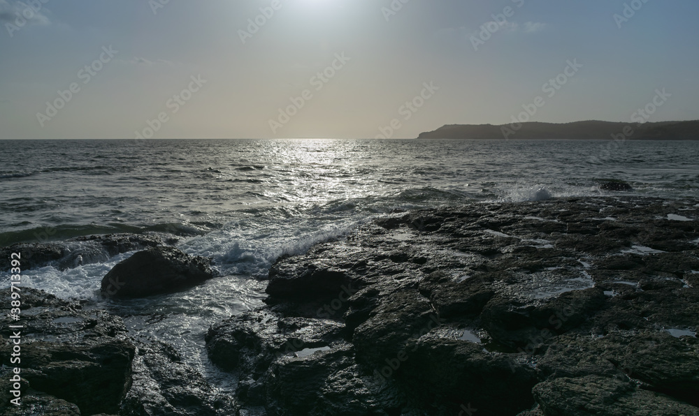 Obraz premium Panoramic view of sea waves flowing and foaming into rocks of Velneshwar beach, India
