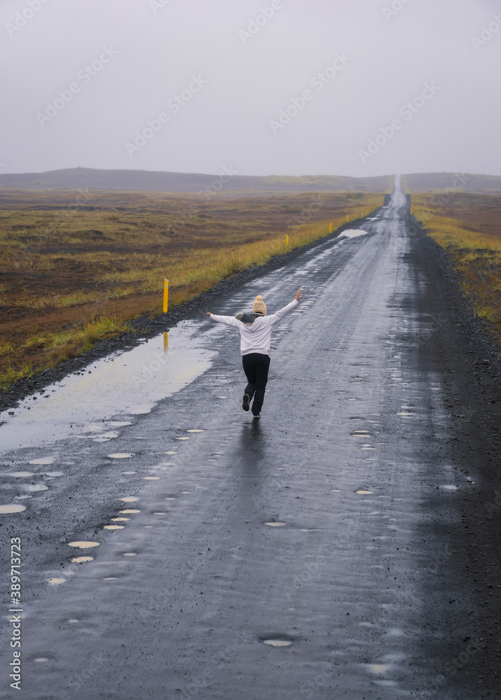 Woman running on a lonely road in Iceland